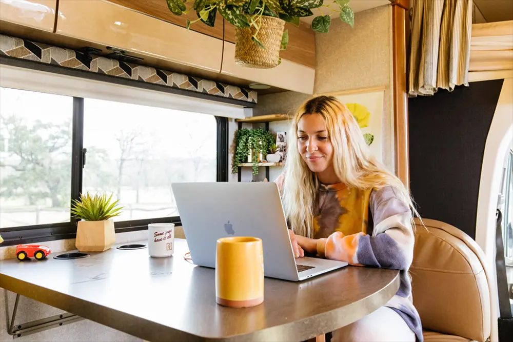 Kleine vaste werkplek met laptop op een standaard langs de zijwand van een camper.