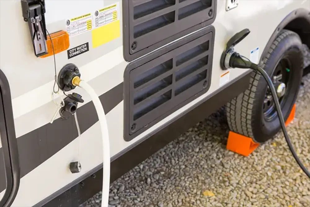 Waterstraal die in de vulopening van de watertank van een camper loopt.
